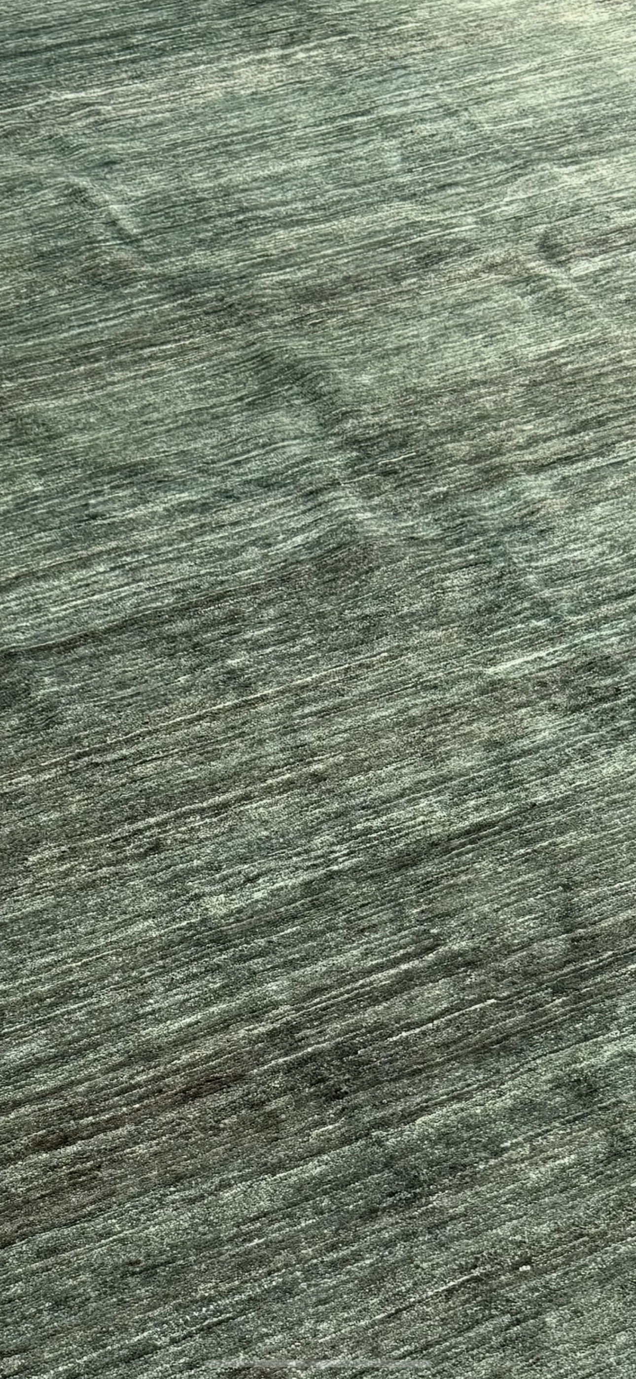 A close up shot of the texture from a forest green wool rug made in Afghanistan.