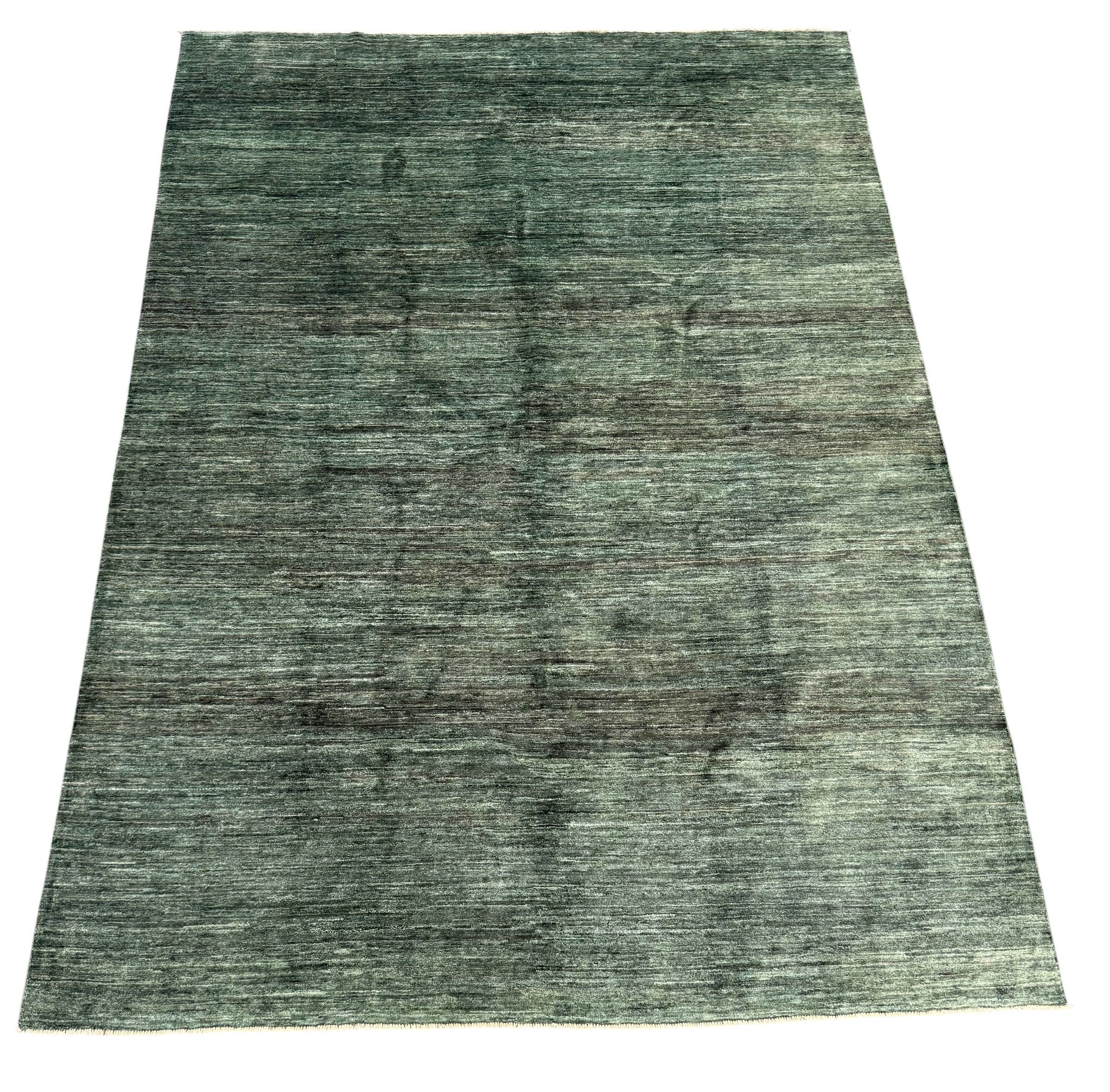 A rectangular area rug with a distressed, heathered texture in muted green and gray tones, shown flat against a plain white background.