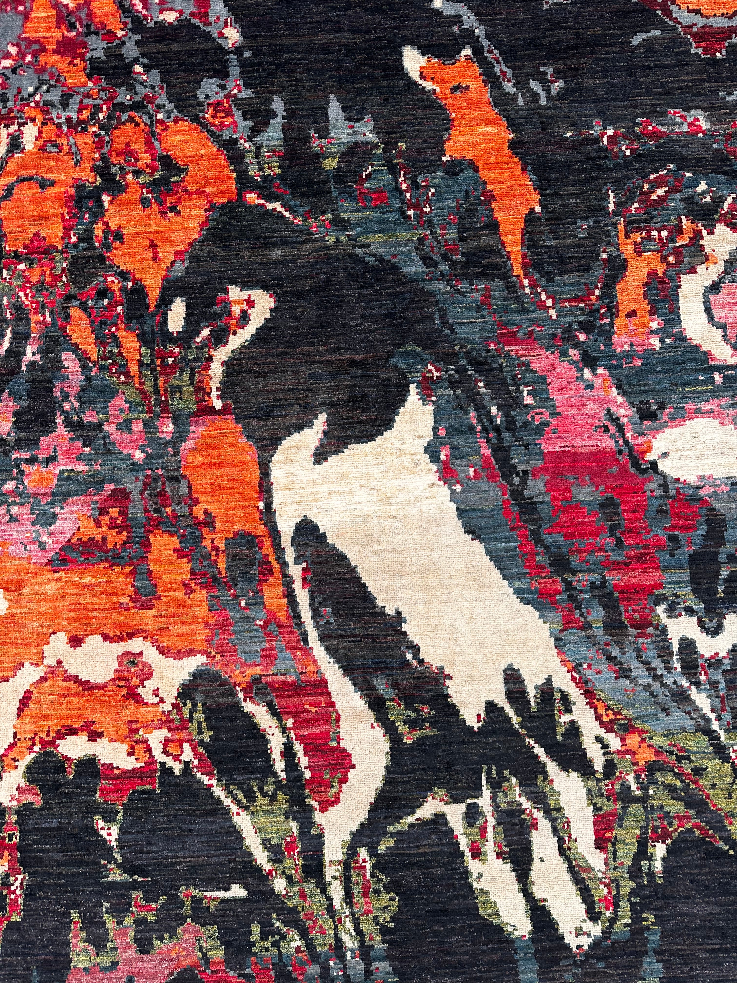 A close-up of an abstract patterned textile or rug with bold brush-like areas of orange, red, black, cream, and muted blue-gray.